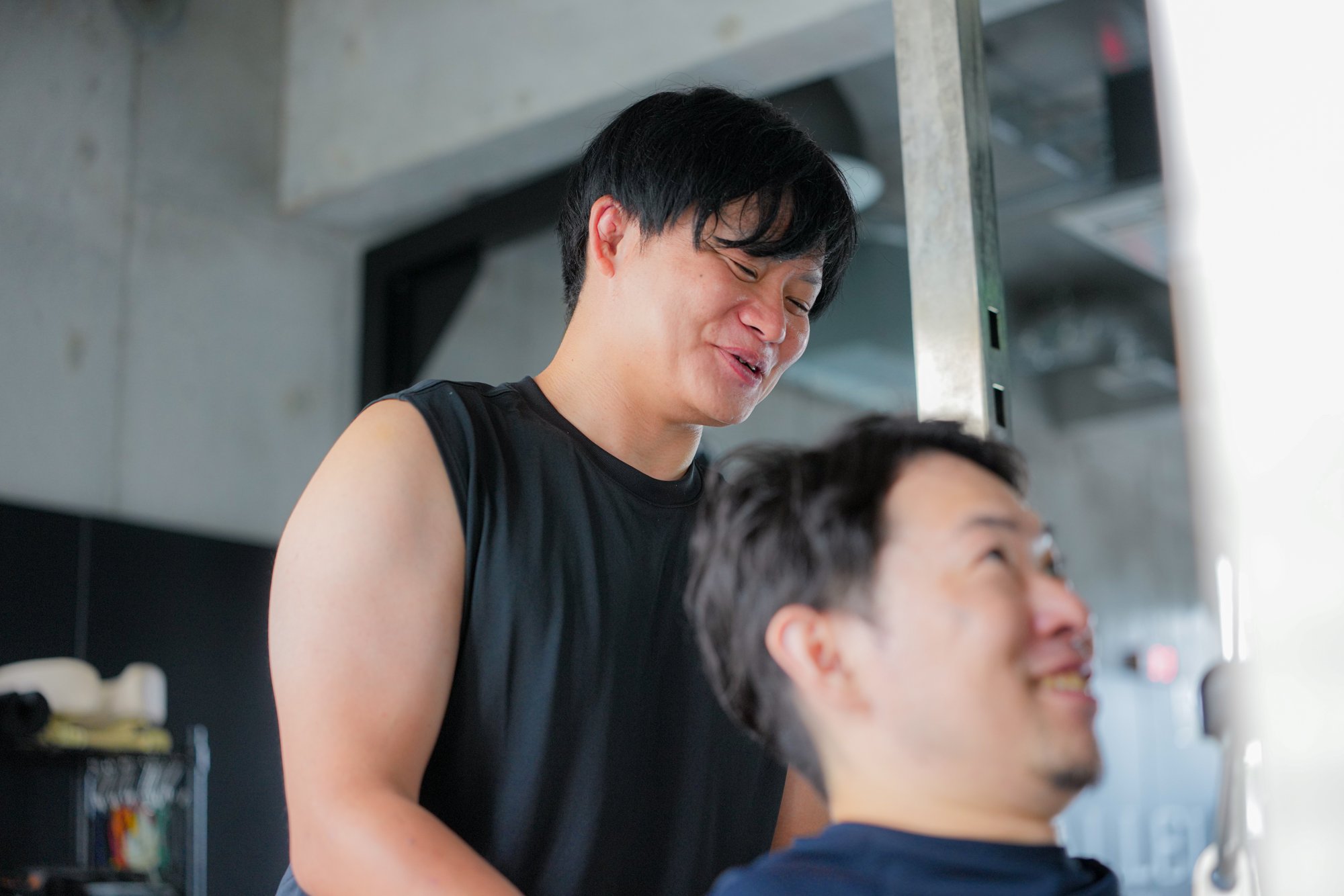 トレーニング中に笑い合うトレーナーと会員